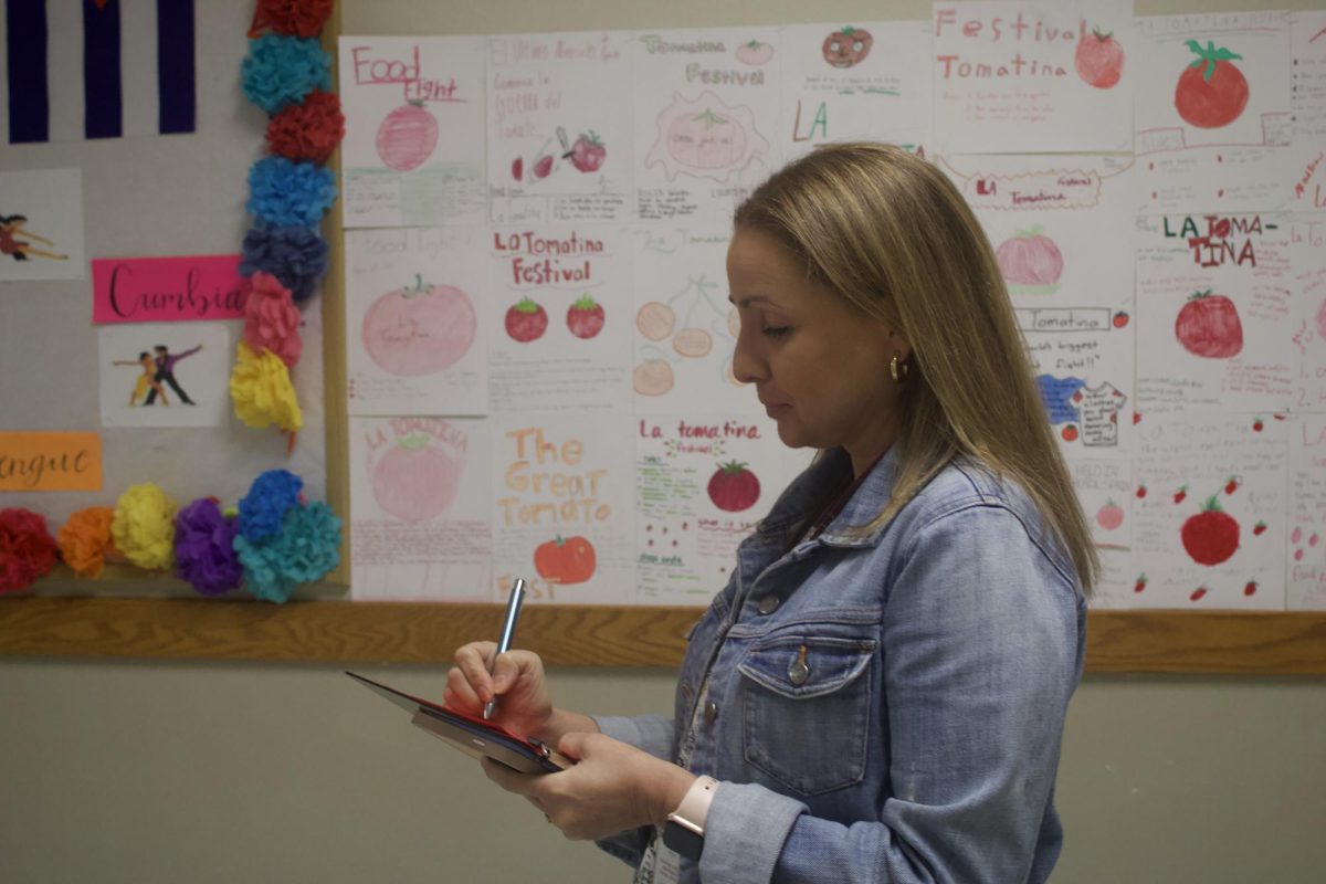 Assistant principal Melissa Spozio writing up red slips to enforce students arriving to class by 9 am