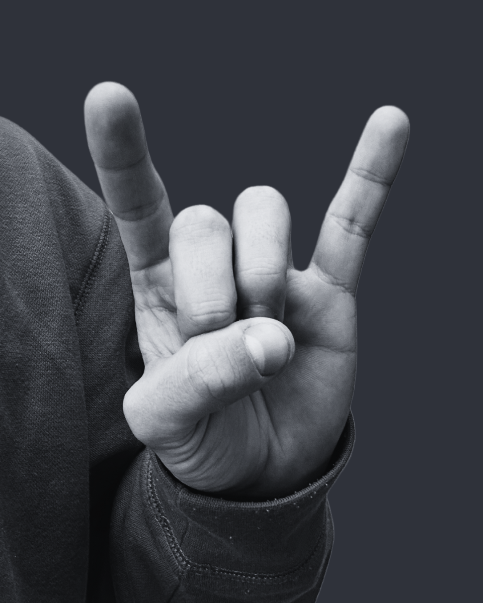 Senior Walter Bristol holding the trademark "hook 'em" after his acceptance to the Moody College of Communications.